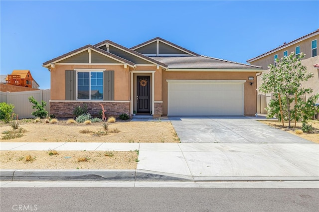 6118 W W Ave J9, Lancaster, CA 93536 - view of front facade featuring an attached garage, concrete driveway, stone siding, and stucco siding