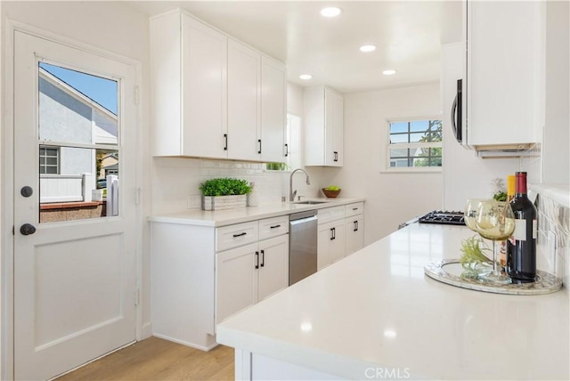 4519 Darien St, Torrance, CA 90503 - kitchen with dishwasher, light wood-style floors, decorative backsplash, light countertops, and white cabinets