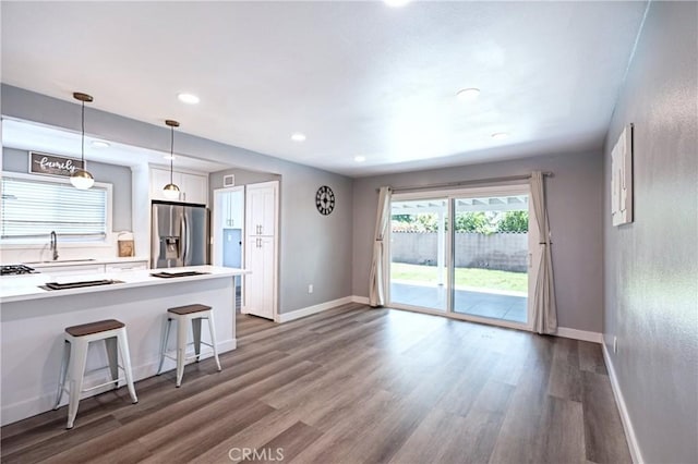 3624 Ardilla Ave, Baldwin Park, CA 91706 - kitchen with stainless steel refrigerator with ice dispenser, white cabinetry, dark wood-type flooring, a kitchen breakfast bar, and a sink