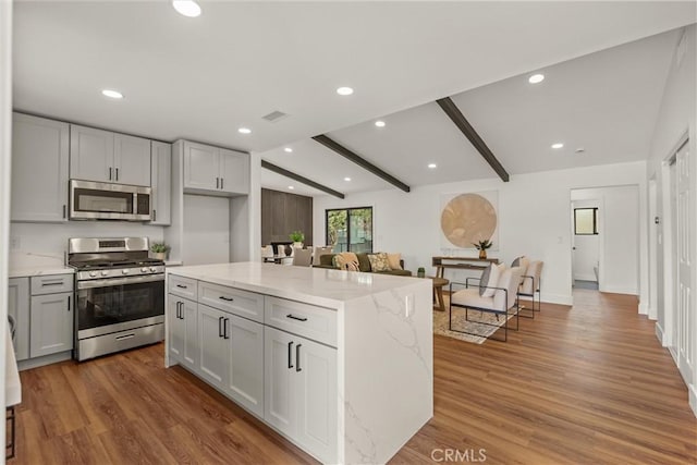 1792 Crestmont Pl, Costa Mesa, CA 92627 - kitchen featuring appliances with stainless steel finishes, light stone countertops, wood finished floors, beam ceiling, and gray cabinets