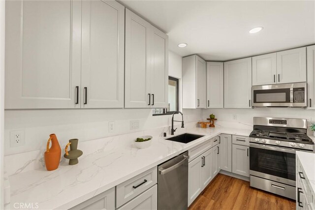 1792 Crestmont Pl, Costa Mesa, CA 92627 - kitchen with stainless steel appliances, a sink, light stone countertops, recessed lighting, and wood finished floors
