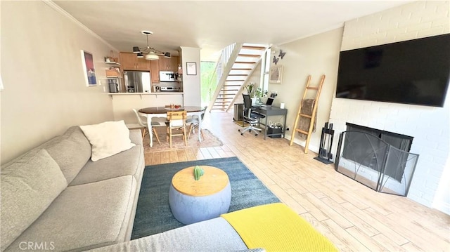 5951 Canterbury Dr Unit 17, Culver City, CA 90230 - living room featuring wood finished floors, stairs, crown molding, a fireplace, and a ceiling fan