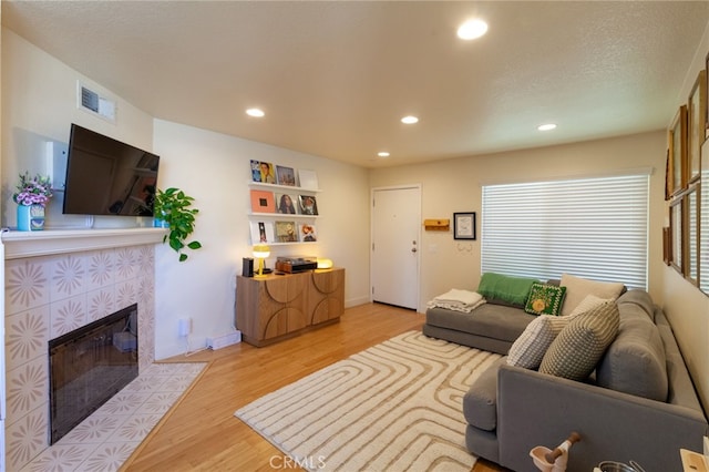 5706 Fair Ave Unit 100, North Hollywood, CA 91601 - living room with recessed lighting, light wood finished floors, and a tile fireplace