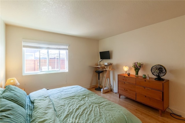 5706 Fair Ave Unit 100, North Hollywood, CA 91601 - bedroom featuring light wood-style flooring, a textured ceiling, and baseboards