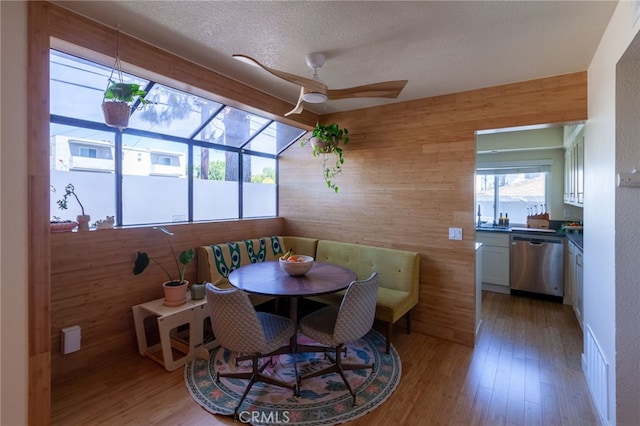 5706 Fair Ave Unit 100, North Hollywood, CA 91601 - dining room with a ceiling fan, light wood-style floors, a textured ceiling, wooden walls, and breakfast area