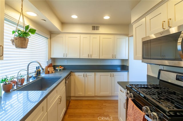 5706 Fair Ave Unit 100, North Hollywood, CA 91601 - kitchen featuring stainless steel appliances, a sink, light wood-type flooring, white cabinetry, and recessed lighting