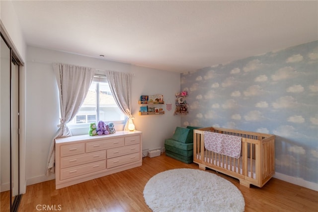 5706 Fair Ave Unit 100, North Hollywood, CA 91601 - bedroom featuring light wood-style floors, baseboards, a crib, and a closet