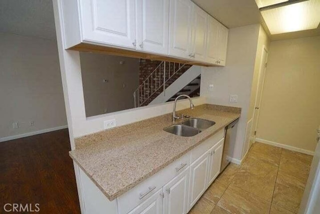 28093 Robin Ave Unit 150, Saugus, CA 91350 - kitchen with white cabinetry, dishwasher, tasteful backsplash, and light stone counters