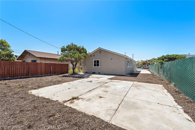 1005 E Cruces St, Wilmington, CA 90744 - rear view of house featuring a fenced backyard, stucco siding, and a patio
