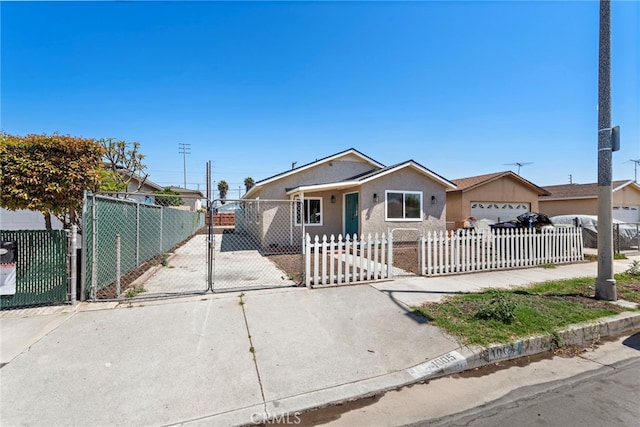 1005 E Cruces St, Wilmington, CA 90744 - view of front of house with stucco siding, a fenced front yard, and a gate