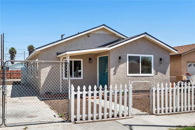 1005 E Cruces St, Wilmington, CA 90744 - bungalow-style home with stucco siding, a fenced front yard, and a gate
