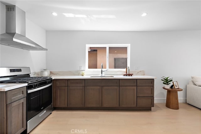 1005 E Cruces St, Wilmington, CA 90744 - kitchen with wall chimney range hood, gas range, a sink, light countertops, and recessed lighting