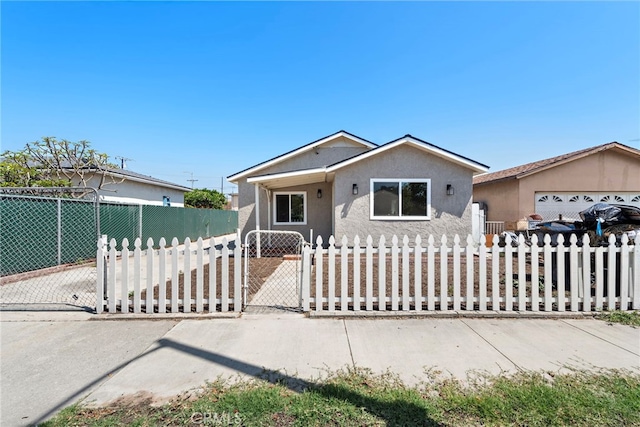 1005 E Cruces St, Wilmington, CA 90744 - view of front of property with stucco siding, a fenced front yard, a garage, and a gate