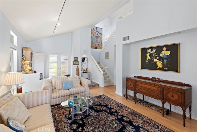 30252 Sonrisa Ln, Laguna Niguel, CA 92677 - living room featuring rail lighting, stairway, wood finished floors, high vaulted ceiling, and french doors
