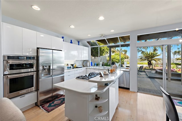 30252 Sonrisa Ln, Laguna Niguel, CA 92677 - kitchen with stainless steel appliances, light wood-style flooring, light countertops, open shelves, and white cabinetry