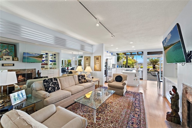 30252 Sonrisa Ln, Laguna Niguel, CA 92677 - living area with a fireplace, light wood finished floors, a textured ceiling, track lighting, and recessed lighting