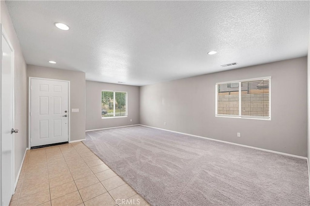 3057 Kilt Ct, Lancaster, CA 93535 - entrance foyer with light colored carpet, a textured ceiling, baseboards, recessed lighting, and light tile patterned flooring