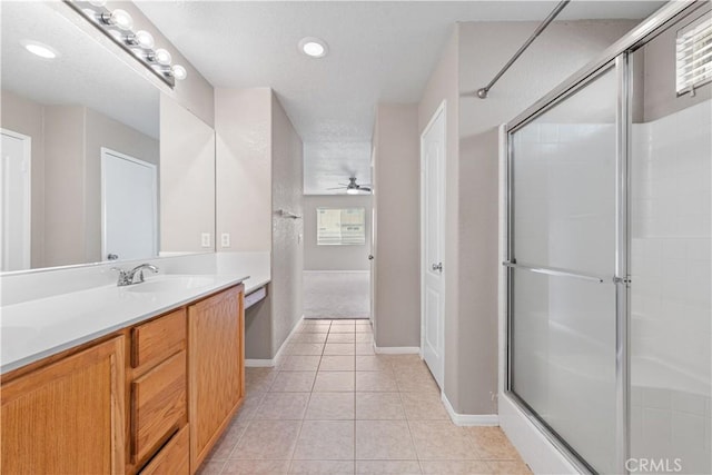 3057 Kilt Ct, Lancaster, CA 93535 - bathroom with double vanity, a shower with door, tile patterned floors, baseboards, and ceiling fan
