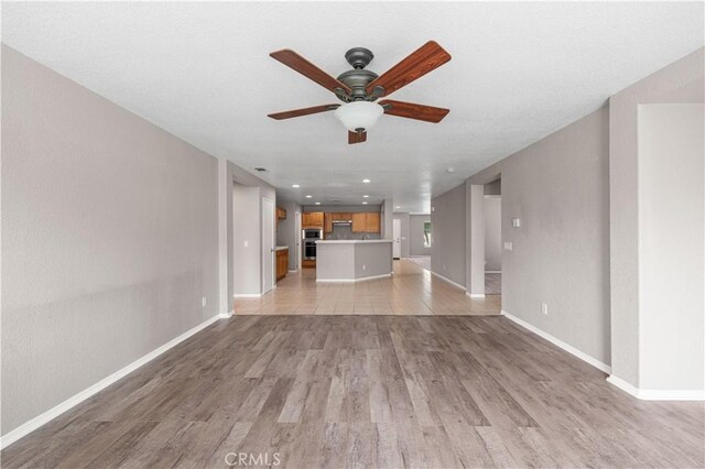 3057 Kilt Ct, Lancaster, CA 93535 - unfurnished living room featuring ceiling fan, baseboards, light wood-type flooring, and recessed lighting