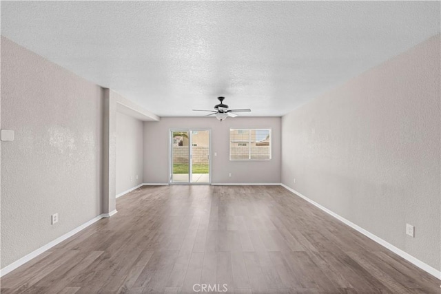 3057 Kilt Ct, Lancaster, CA 93535 - empty room featuring a textured wall, a ceiling fan, wood finished floors, a textured ceiling, and baseboards