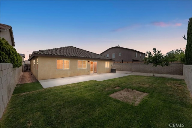 3057 Kilt Ct, Lancaster, CA 93535 - back of house at dusk with a tiled roof, stucco siding, a patio, and central air condition unit
