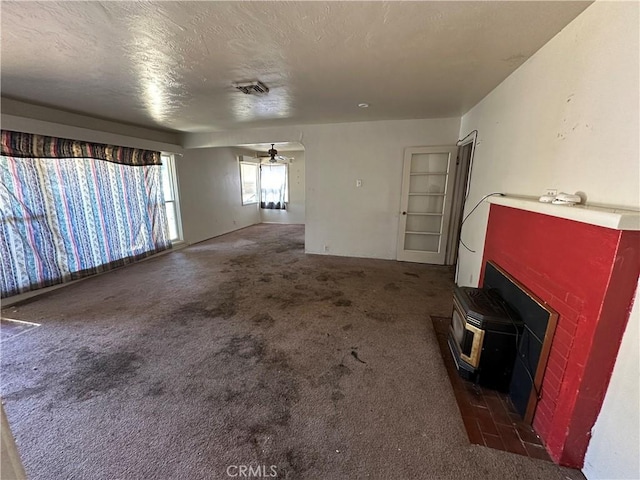 2233 Marguerite St, Dos Palos, CA 93620 - unfurnished living room featuring carpet, a wood stove, and a ceiling fan