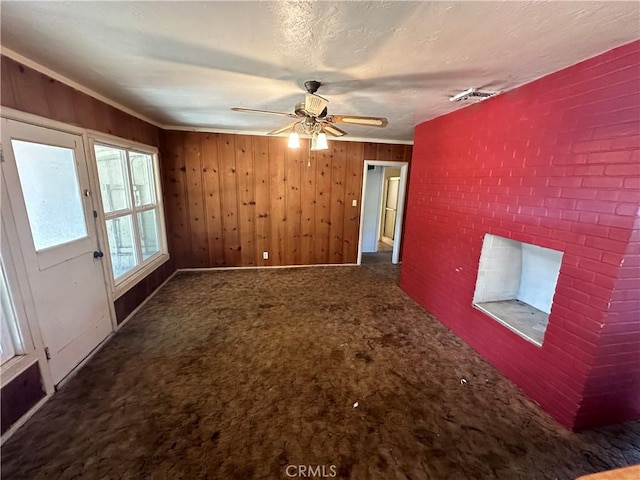 2233 Marguerite St, Dos Palos, CA 93620 - unfurnished living room featuring carpet flooring, wooden walls, ceiling fan, and a brick fireplace