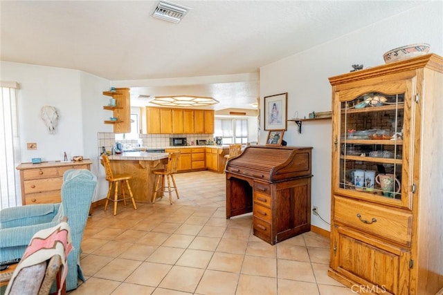 5131 Cygnet Rd A-B, Unit A-B Phelan, CA 92371 - kitchen with a peninsula, a breakfast bar, light tile patterned floors, open shelves, and backsplash