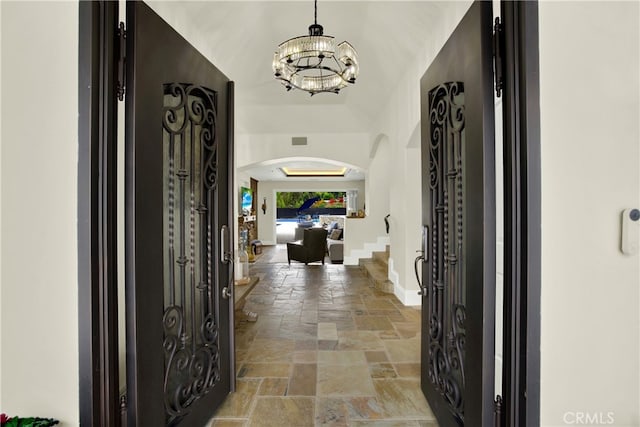 30927 Steeplechase Dr, San Juan Capistrano, CA 92675 - foyer entrance featuring stone tile floors, arched walkways, a chandelier, and baseboards