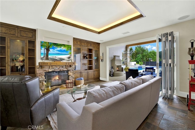 30927 Steeplechase Dr, San Juan Capistrano, CA 92675 - living area featuring built in features, baseboards, a fireplace, and a tray ceiling