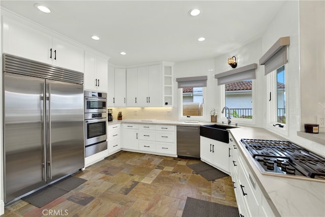 30927 Steeplechase Dr, San Juan Capistrano, CA 92675 - kitchen featuring appliances with stainless steel finishes, a sink, open shelves, dark stone finish flooring, and white cabinets