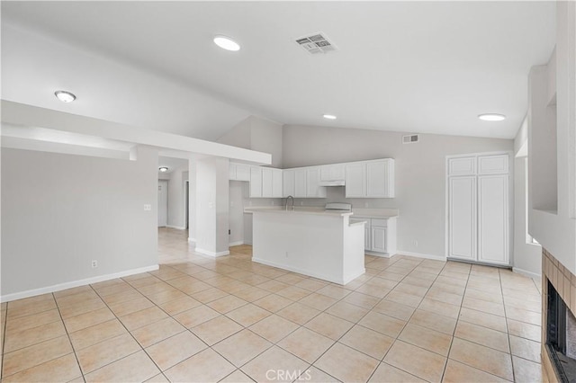 2101 Thomas Dr, Lancaster, CA 93535 - kitchen with vaulted ceiling, light tile patterned flooring, white cabinetry, light countertops, and baseboards