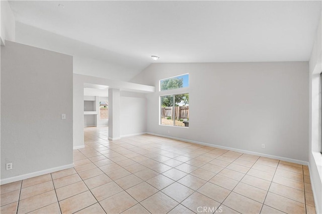 2101 Thomas Dr, Lancaster, CA 93535 - empty room featuring light tile patterned flooring, lofted ceiling, and baseboards