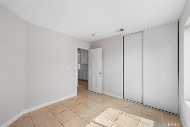 2101 Thomas Dr, Lancaster, CA 93535 - unfurnished bedroom with light tile patterned floors, baseboards, and a closet