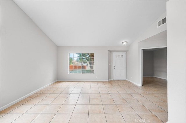 2101 Thomas Dr, Lancaster, CA 93535 - empty room with lofted ceiling, light tile patterned floors, and baseboards