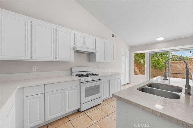 2101 Thomas Dr, Lancaster, CA 93535 - kitchen featuring white gas range, a sink, vaulted ceiling, under cabinet range hood, and light tile patterned flooring