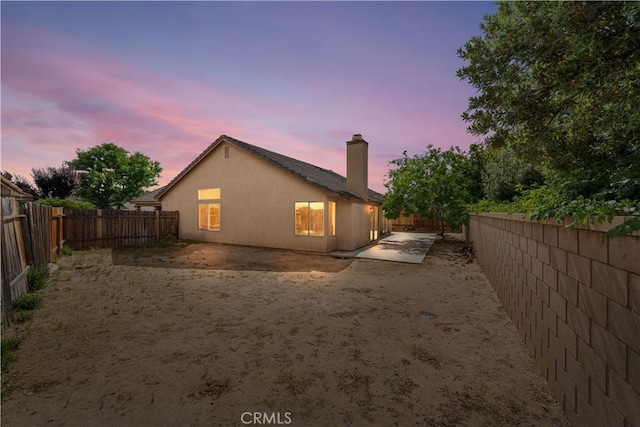 2101 Thomas Dr, Lancaster, CA 93535 - rear view of property featuring a fenced backyard, a chimney, a patio, and stucco siding