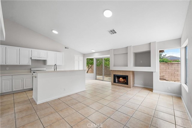 2101 Thomas Dr, Lancaster, CA 93535 - kitchen featuring vaulted ceiling, light countertops, light tile patterned flooring, under cabinet range hood, and white cabinets