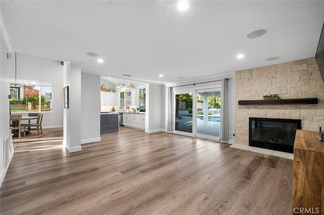 2244 N 1st Ave, Upland, CA 91784 - unfurnished living room with wood finished floors, a stone fireplace, and recessed lighting