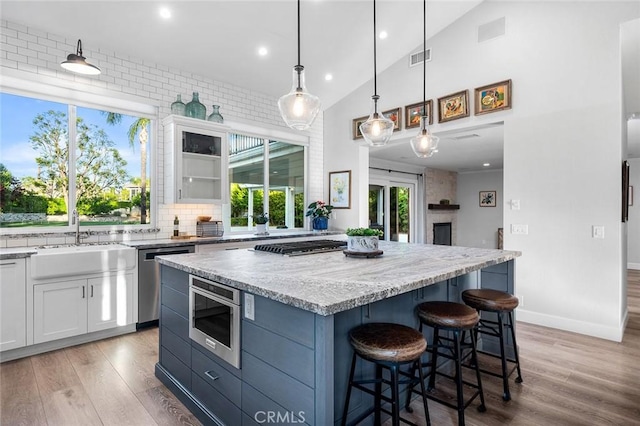 2244 N 1st Ave, Upland, CA 91784 - kitchen with stainless steel appliances, healthy amount of natural light, a breakfast bar area, light wood finished floors, and recessed lighting