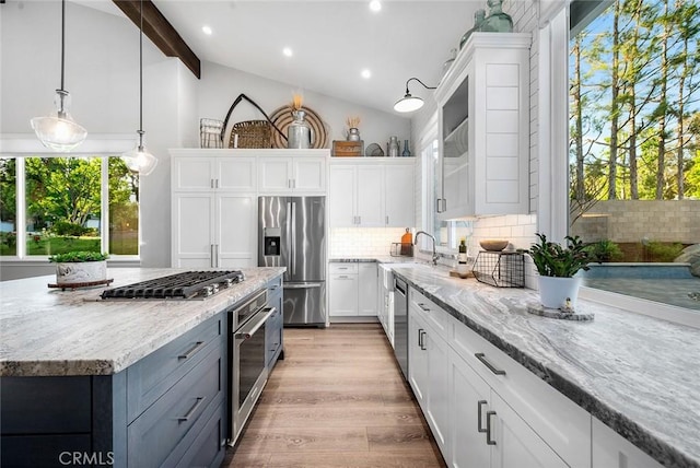 2244 N 1st Ave, Upland, CA 91784 - kitchen with stainless steel appliances, white cabinets, backsplash, light stone counters, and hanging light fixtures