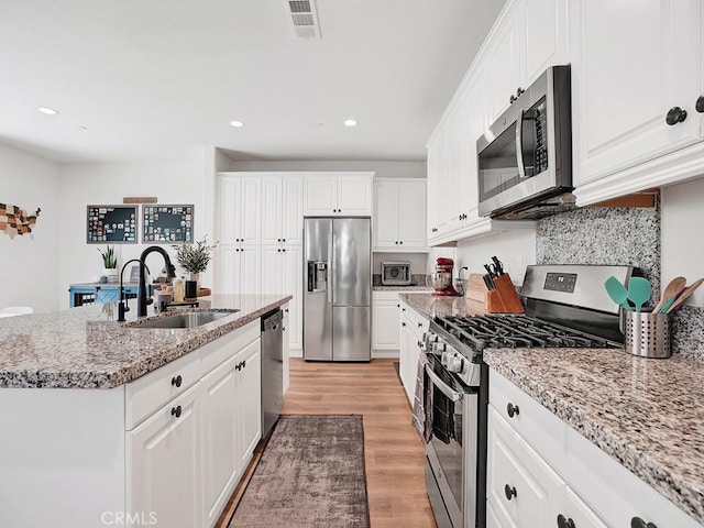 8967 Sunshine Valley Way, Corona, CA 92883 - kitchen featuring stainless steel appliances, a sink, light wood-style floors, white cabinets, and recessed lighting