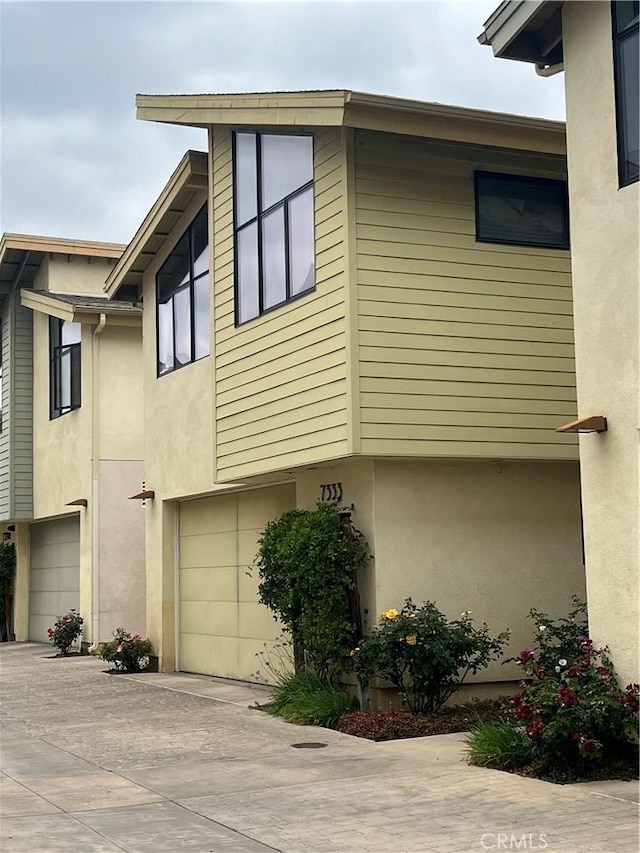 7333 Tampa Ave Unit 7, Reseda, CA 91335 - view of side of home featuring an attached garage, stucco siding, and concrete driveway