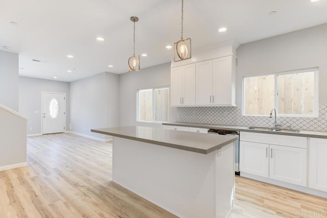 535 60th St, San Diego, CA 92114 - kitchen featuring a sink, backsplash, a center island, white cabinets, and light wood finished floors