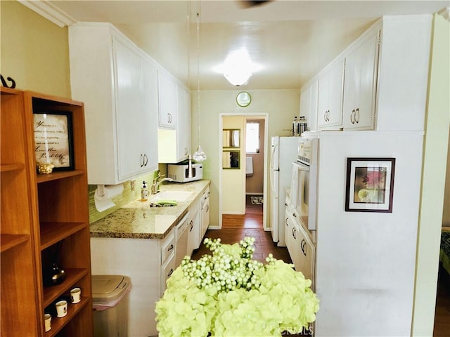 2772 E 2nd St Unit E2, Long Beach, CA 90803 - kitchen featuring white appliances, a sink, white cabinets, and light stone counters