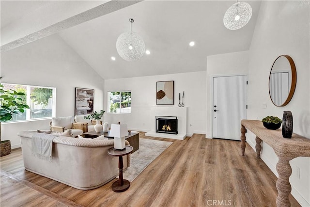 921 Dahlia Ave, Costa Mesa, CA 92626 - living area with high vaulted ceiling, healthy amount of natural light, light wood finished floors, a lit fireplace, and recessed lighting