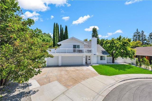 921 Dahlia Ave, Costa Mesa, CA 92626 - view of front of property with a front lawn, concrete driveway, a chimney, a balcony, and a garage