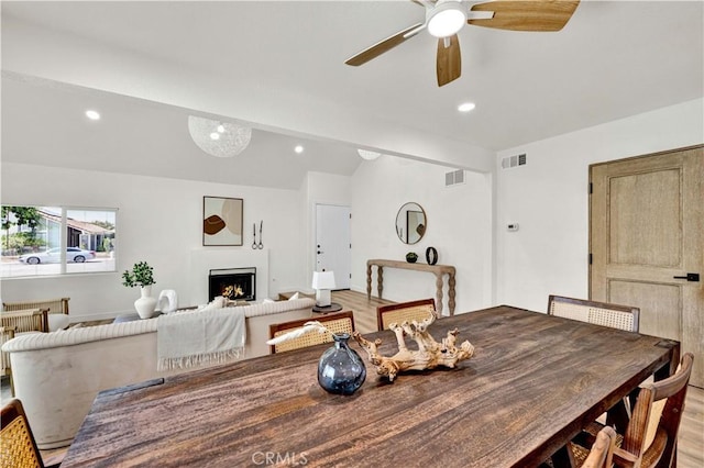 921 Dahlia Ave, Costa Mesa, CA 92626 - dining room featuring vaulted ceiling, light wood-style flooring, a ceiling fan, a lit fireplace, and recessed lighting