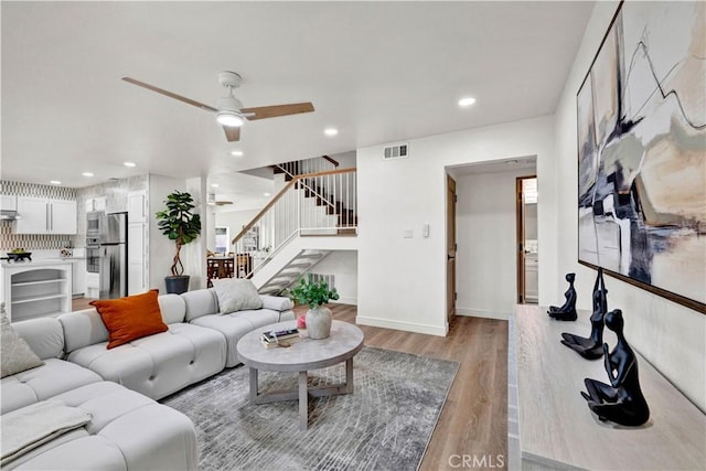 921 Dahlia Ave, Costa Mesa, CA 92626 - living room with stairway, light wood-style floors, ceiling fan, recessed lighting, and baseboards