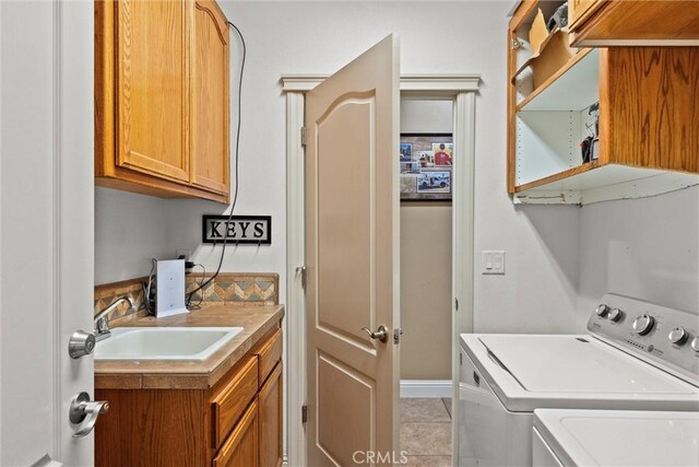 14690 Paynes Creek Rd, Red Bluff, CA 96080 - laundry area featuring cabinet space, washing machine and dryer, and light tile patterned floors